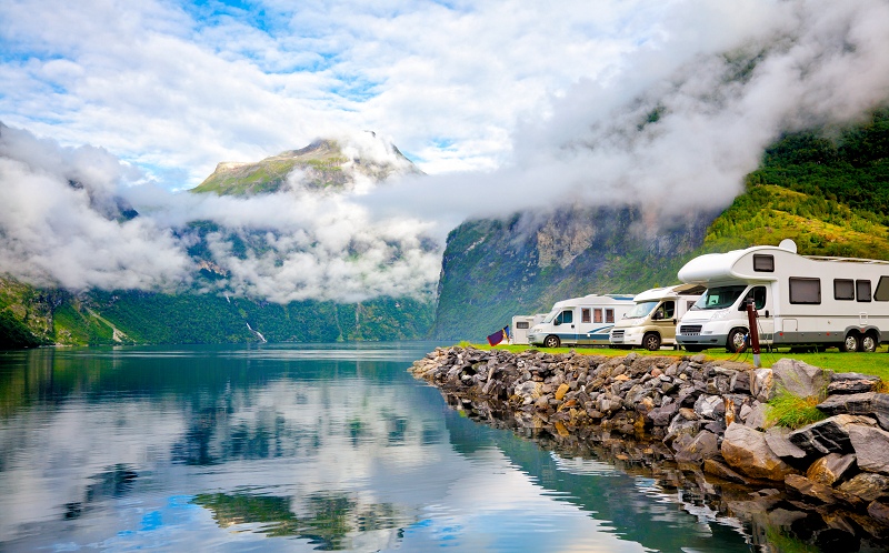 Recreational vehicles parked with a beautiful mountain lake view